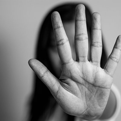 Woman's outstretched hand to camera, obscuring her face